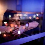 brand image - Child looking out a window at night with reflections of light