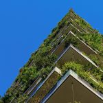 Upwards view of balconies on a high rise building overflowing with foliage