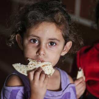 A girl eating bread. Photo: WFP/Ali Jadallah