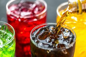 pouring sugary beverage into glass