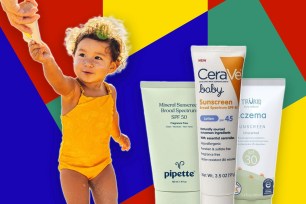 A baby in a yellow swimsuit with sunscreen and several tubes of sunscreen