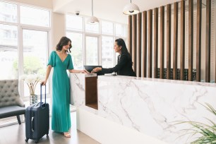 A woman signs into a hotel.