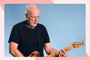 David Gilmour plays guitar onstage.