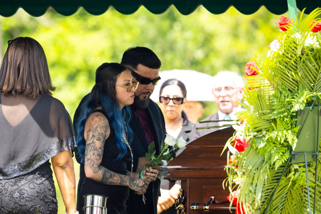Jocelyn's mother Alexis stands alongside her father in front of her daughter's casket.