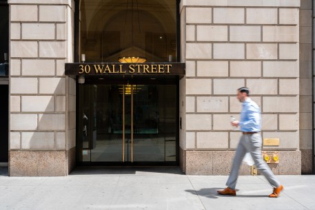 Worker walking pass a building at Wall Street.