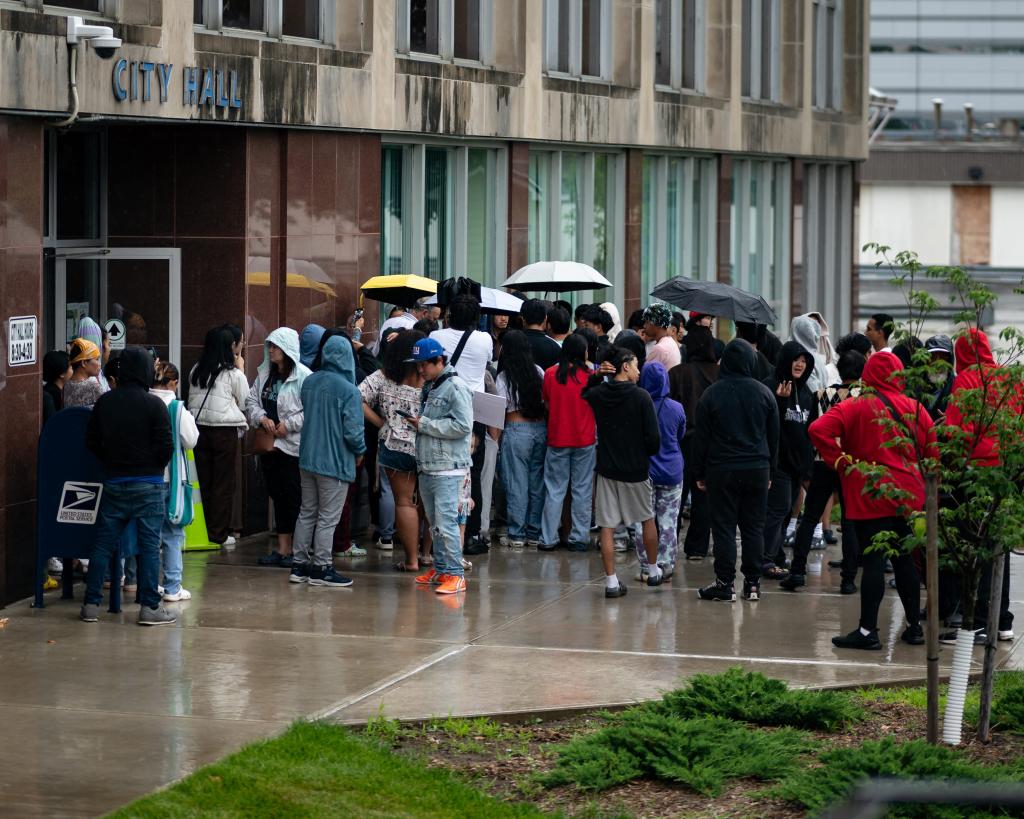 A crowd gathers outside City Hall in Utica, NY on Saturday, 