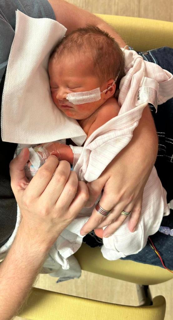 A pregnant Clare Foreman resting on her couch, wrapped in a blanket, prior to experiencing leg and abdominal pain