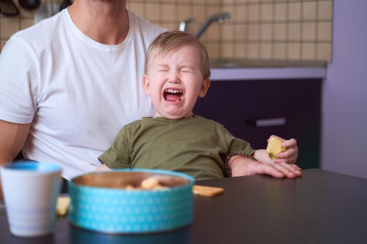 Small child bitterly bursts in tears, capricious, has bad mood, takes out brain of parents, tearfully asks to play, yells, throws tantrums