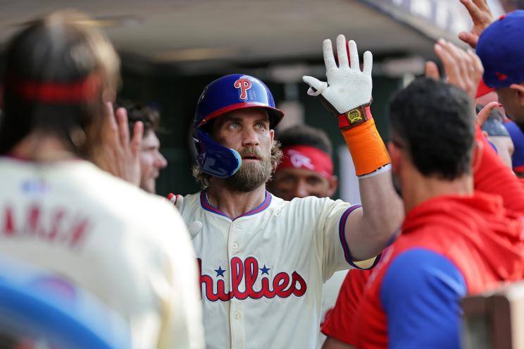 Bryce Harper of the Philadelphia Phillies celebrating with teammates in the dugout after hitting a solo home run against the Oakland Athletics