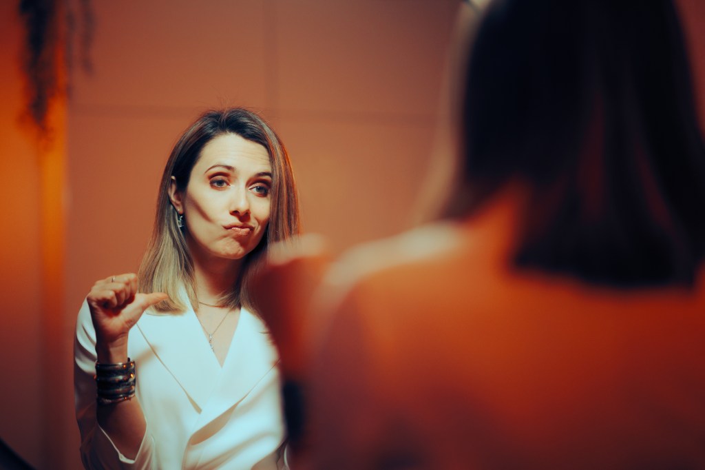 Woman giving a thumbs down in the mirror