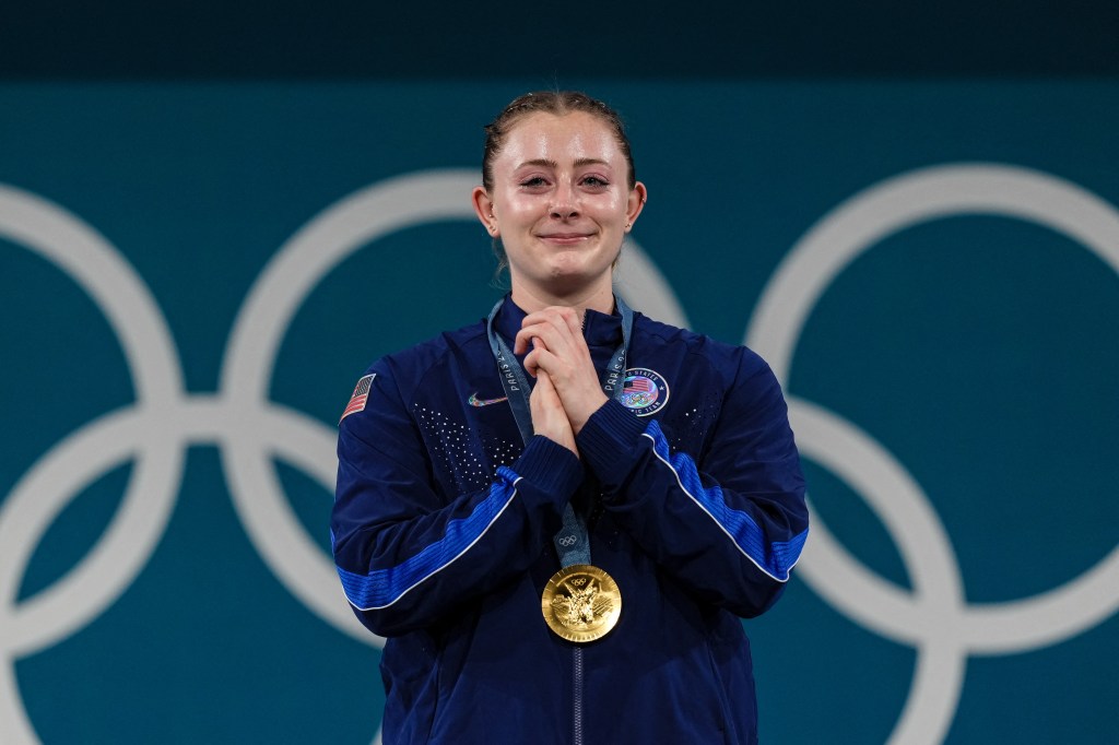 Gold medallist Olivia Reeves reacting with joy on the podium after winning the women's -71kg weightlifting event during the Paris 2024 Olympic Games