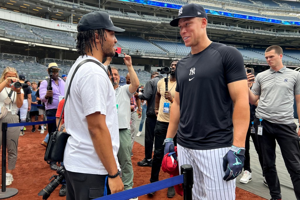 ankees center fielder Aaron Judge (99) talks to New York Knicks guard Jalen Brunson before a game against the New York Mets at Yankee Stadium.