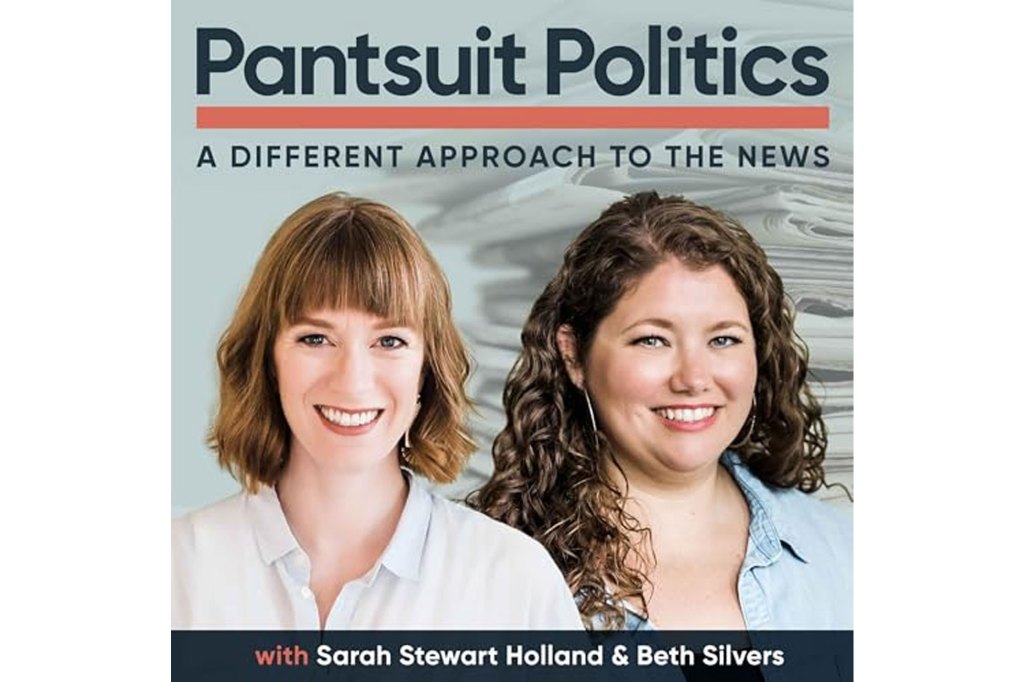 Two women in pantsuits smiling for a photo