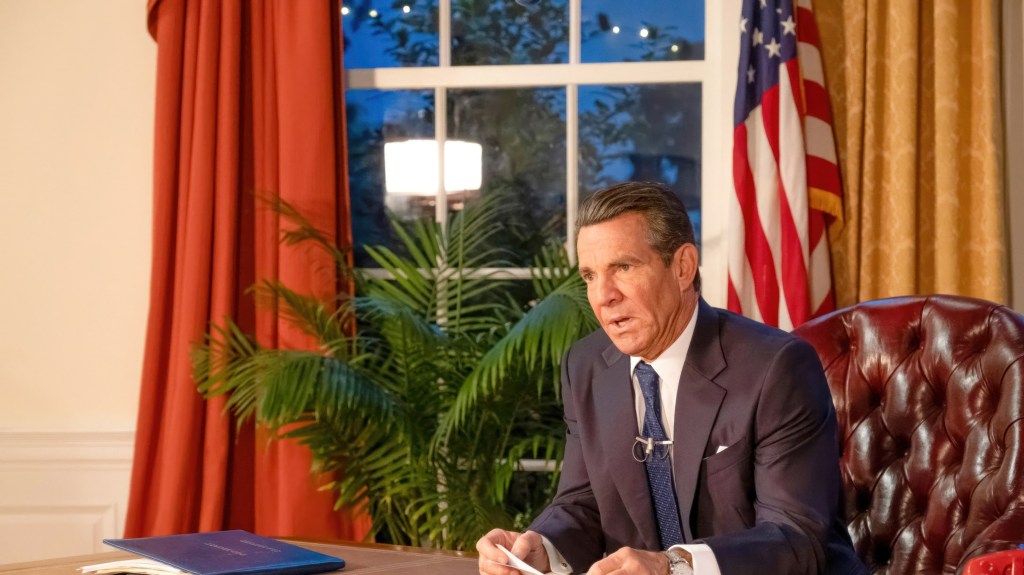 Dennis Quaid portraying Ronald Reagan sitting at a desk in the 2024 movie REAGAN.