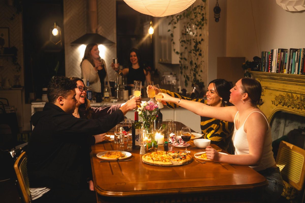 Four people toast over dinner.