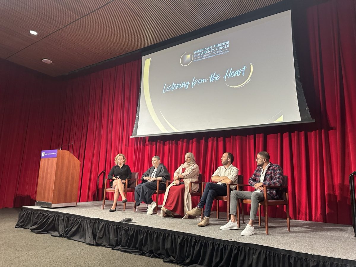 Five panelists sit on a stage in front of a red curtain and a screen that reads “Listening from the Heart.”