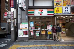 Two boys stand outside entrance to 7-Eleven convenience store on street