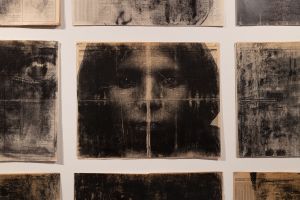 Photo prints of faces on hanging fabric