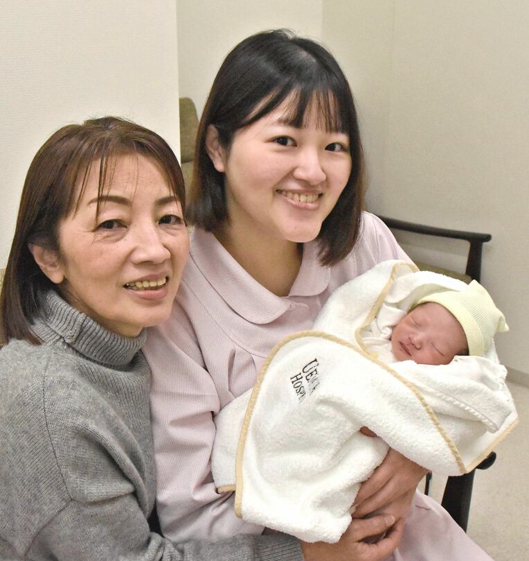 元日に産まれた長男を抱く坂梨葉月さん（右）と坂梨さんの母の伊佐信子さん＝１日、中城村・うえむら病院