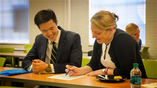 A female alumna reviewing the resume of an operations research student