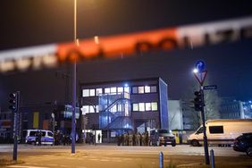 Police officers gather at the scene of a shooting that has left at least six people dead and four wounded in Alsterdorf district