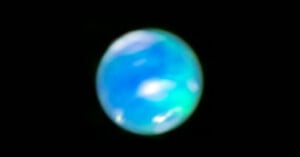 A blurry, spherical object with blue and green hues set against a black background, resembling an abstract representation of a planet.