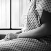 Midsection of female patient waiting in hospital exam room