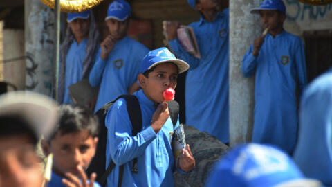 À Jaffarabad, en plein été, un étudiant savoure une glace à la sortie de son école.