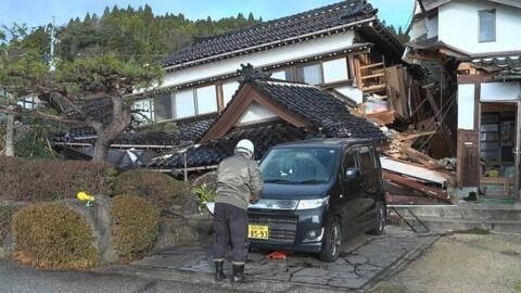 Un homme devant une maison détruite à Wajima, dans la préfecture d'Ishikawa, au lendemain d'un séisme de magnitude 7,5, le 2 janvier.