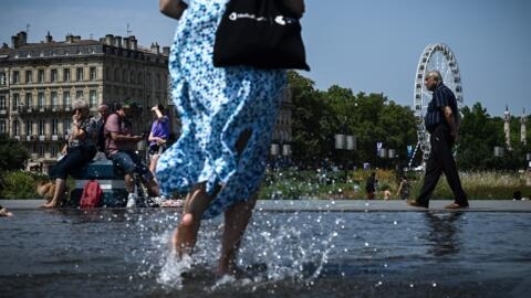 Une femme marche pieds nus sur le "Miroir d'Eau" à Bordeaux.