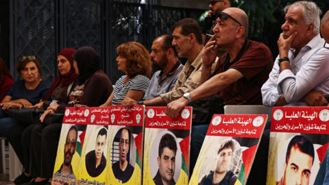 People lift placards bearing portraits of Palestinians currently detained by Israel during a protest in solidarity with them and with the residents of the Gaza Strip in Ramallah.