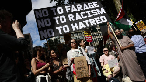 Des manifestants brandissent des pancartes antiracistes devant le siège de Reform UK à Londres le 10 août 2024.