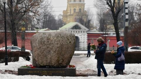 People lay flowers for the late Russian opposition leader Alexei Navalny at the monument to the victims of political repression in Saint Petersburg on February 24, 2024.