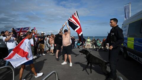 Des manifestants anti-immigration font face à un policier dans la ville de Weymouth, dans le sud-ouest de l'Angleterre, le 4 août 2024.