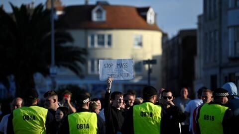 Des policiers font face aux manifestants mobilisés par des militants d'extrême droite à Weymouth, en Angleterre, dimanche 4 août 2024.