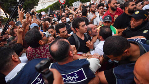 Tunisian demonstrators scuffle with security forces during a protest against President Kais Saied on October 4 2024, in Tunis. 