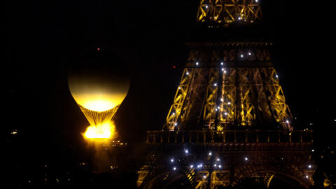 The Olympic cauldron is seen lit and and rising in a hot-air balloon beside the Eiffel Tower during the Opening Ceremony.
