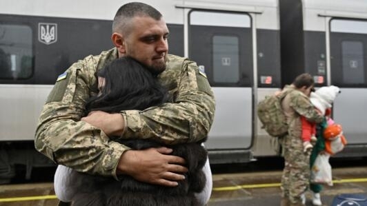 Ukrainian servicemen Dmytro, 29-years-old, embraces his wife before she boards a train heading to Kyiv, at a railway station in Kramatorsk, Donetsk region, on October 8, 2023