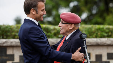 Achille Muller (R), 98, last survivor of the Free French Forces, and France's President Emmanuel Macron embrace during a ceremony commemorating SAS paratroopers and Free French Forces.