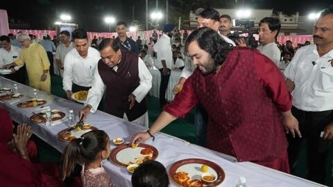 تظهر هذه الصورة التي التقطت في 28 فبراير 2024، رجل الأعمال الهندي موكيش أمباني وابنه أنانت خلال إطعامهما فقراء في احتفال ما قبل زفاف أنانت في جامناجار.