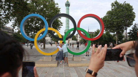 قبل يوم واحد من حفل افتتاح دورة الألعاب الأولمبية في باريس 2024، سياح يلتقطون صورا أمام الحلقات الأولمبية. في باريس، 25 يوليو/تموز 2025.