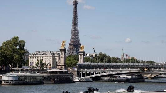 ضباط شرطة وهم يقومون بدوريات على متن قوارب على نهر السين جانب جسر ألكسندر الثالث وبرج إيفل لتفقد موقع تنظيم حفل افتتاح الالعاب الاولمبية. باريس في 17 يوليو/تموز 2024.
