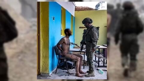 This is a photo of a Palestinian detainee looking directly at an Israeli soldier while being restrained in a primary school in Gaza. It was shared in December on YouTube by an Israeli reservist. The detainee’s face has been blurred. © Yosee Gamzoo
