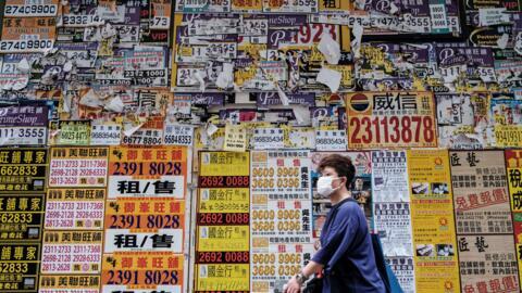 A pedestrian walks past a closed shop in Hong Kong, 20 July 2020.