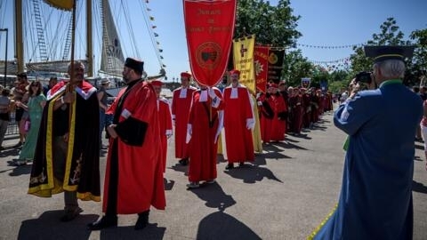 Members of Bordeaux wine confreries (guilds) march on the banks of the Garonne River as part of the Bordeaux Wine Festival, in Bordeaux, southwestern France on June 24, 2023. Made of professionals and