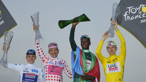 Le podium du Tour de France 2024. De droite à gauche, son vainqueur en jaune, le Slovène Tadej Pogacar, l'Érythréen Biniam Girmay, meilleur sprinter, l'Équatorien Richard Caparaz, meilleur grimpeur...
