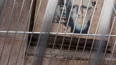 A poster depicting Abbé Pierre is displayed through the railings on 19 October 2007 in the rue de la Banque in Paris..