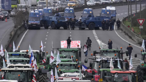 Gendarmes with armored vehicles face farmers and their tractors blocking a highway, Wednesday, Jan. 31, 2024 in Chilly-Mazarin, south of Paris. French farmers maintained their protests on major roads 