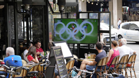 People watch a rugby match between France and Fiji at a street cafe during the 2024 Summer Olympics, Thursday, July 25, 2024, in Paris, France.