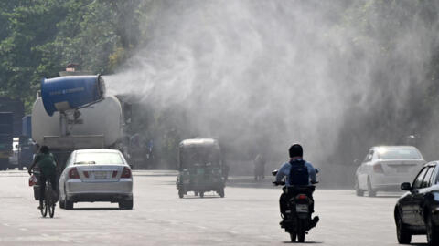 A vehicle of the Dhaka North City Corporation sprays water along a busy road to lower the temperature amidst a heatwave in Dhaka, Bangladesh, on 27 April, 2024.